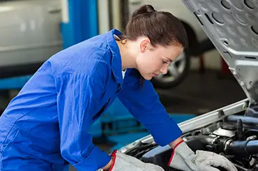 Mechanic inspecting car engine Female mechanic inspecting car engine